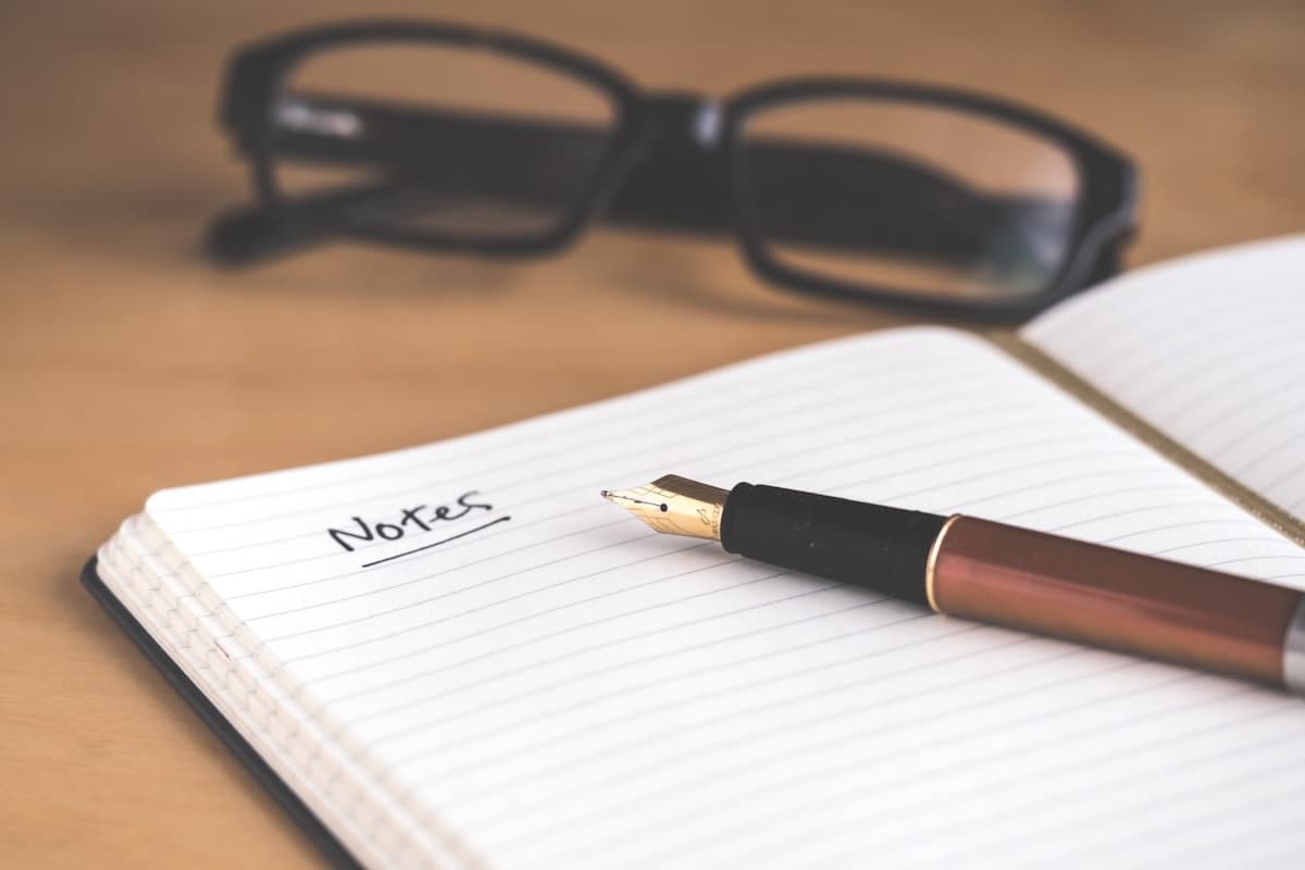 Cuaderno abierto y lentes sobre una mesa